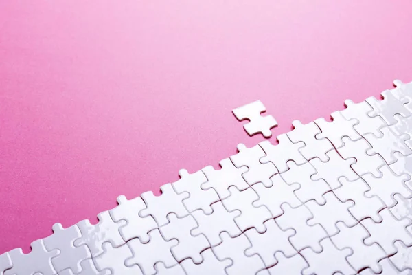 Witte puzzel op roze achtergrond. Bovenaanzicht — Stockfoto