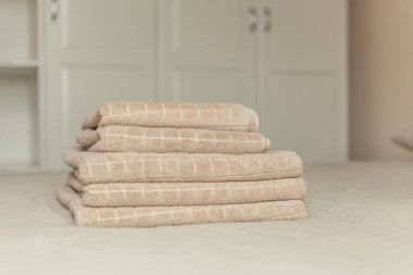 Yatak yatak odası iç bej otel havlu yığını. Vintage tonlama. Yumuşak odak.