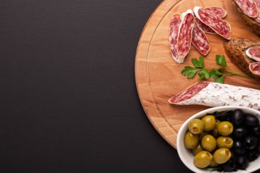 Salam ve siyah arka plan üzerine ekmek. Üstten görünüm. Kopya alanı