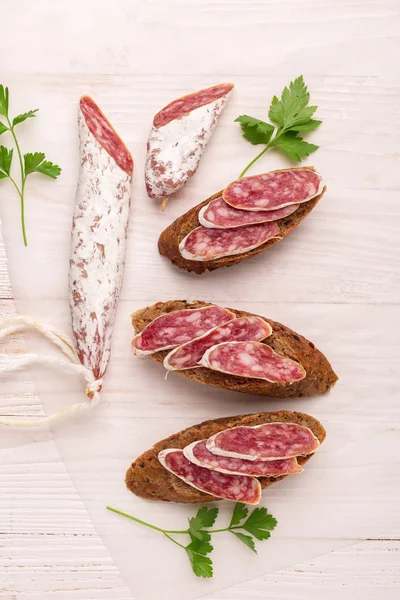 Salami Und Brot Auf Weißem Holzgrund Ansicht Von Oben Kopierraum — Stockfoto