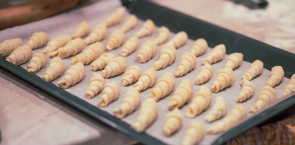 Ev yapımı simit bir fırın tepsisine. Ekmek pişirme için hazırlanmış. Noel kavramı. Vintage renklendirme