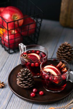 Gözlük ahşap arka plan üzerinde mulled şarap. Elma, kızılcık, tarçın, Yıldız anason.