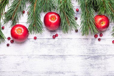 Noel arka plan ağaç dalları, kırmızı elma ve cranberries ile. Ahşap masa lambası