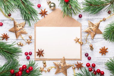 Çam dalları, hediyeler ve hafif ahşap arka plan üzerinde bir zarf. Kızılcık, baharat, holly Karpuzu. Noel arka plan. Düz yatıyordu, en iyi görünüm, kopya alanı.