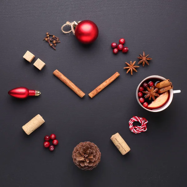 A clock in the form of spice for mulled wine. Cinnamon, anise stars, cranberries, brown sugar. Concept, creative work. Time to cook mulled wine. Top view. Black background. Square