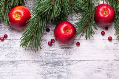 Noel arka plan ağaç dalları, kırmızı elma ve cranberries ile. Ahşap masa lambası. Üstten görünüm. Kopya alanı