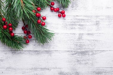 Noel ağaç dalları ve holly Karpuzu arka plan. Beyaz ahşap masa. Üstten görünüm. Kopya alanı