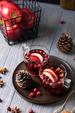 Gözlük ahşap arka plan üzerinde mulled şarap. Elma, kızılcık, tarçın, Yıldız anason, ceviz, koniler