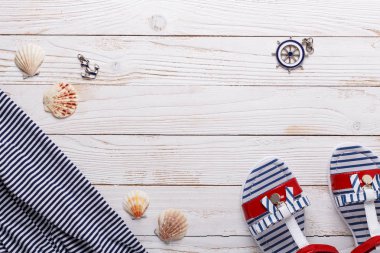 Tatil kavramı sandalet, kabukları ve çizgili tişört ile seyahat. Üstten görünüm kopya alanı ile. Düz yatıyordu