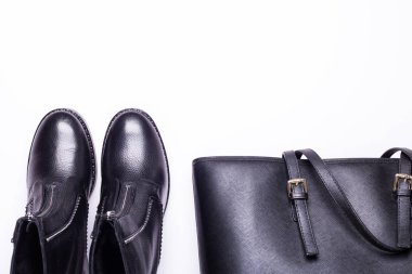 Kadın aksesuar. Beyaz arka planda siyah şık çizmeler, siyah lüks deri çanta. Üstten görünüm arka plan. Düz yatıyordu. Kopya alanı.