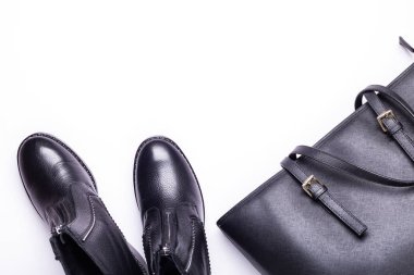 Kadın aksesuar. Beyaz arka planda siyah şık çizmeler, siyah lüks deri çanta. Üstten görünüm arka plan. Düz yatıyordu. Kopya alanı.