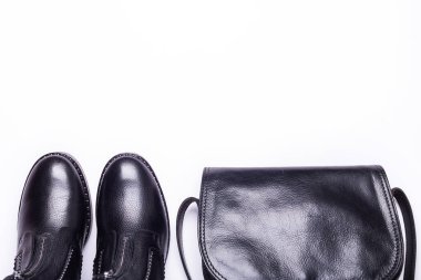 Kadın aksesuar. Beyaz arka planda siyah şık çizmeler, siyah lüks deri çanta. Üstten görünüm arka plan. Düz yatıyordu. Kopya alanı.