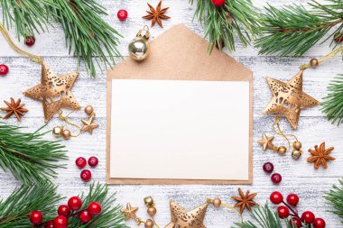 Çam dalları, hediyeler ve hafif ahşap arka plan üzerinde bir zarf. Kızılcık, baharat, holly Karpuzu. Noel arka plan. Düz yatıyordu, en iyi görünüm, kopya alanı.