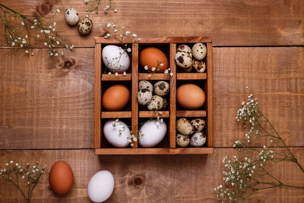 Eggs in wooden box on the table. Top view, copy space