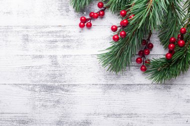 Noel ağaç dalları ve holly Karpuzu arka plan. Beyaz ahşap masa. Üstten görünüm. Kopya alanı