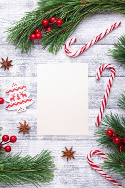 Noel arka plan. Çam dalları, şeker kamışı ve hediyeler hafif ahşap arka plan üzerinde. Kızılcık, baharat, holly Karpuzu. Düz yatıyordu, en iyi görünüm, kopya alanı.