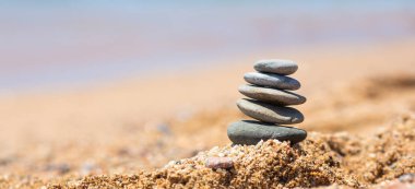 Denge taş sahilde, güneşli bir gün. Sahilde kum