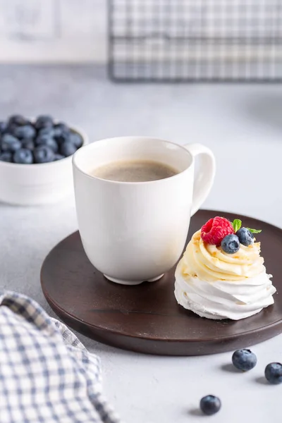 Kaffeebecher Und Pavlova Kuchen Mit Schlagsahne Und Frischen Beeren Auf — Stockfoto