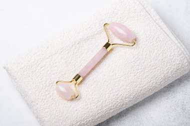 Rose Quartz taştan arka planda havluyla yeşim taşı yuvarlıyor. Yüz bakımı için masaj aracı, SPA güzellik tedavi konsepti - Görüntü