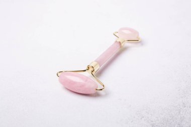 Taş arka planda Rose Quartz yeşim taşı silindiri. Yakın plan. Yüz bakımı için masaj aracı, SPA güzellik tedavi konsepti - Görüntü