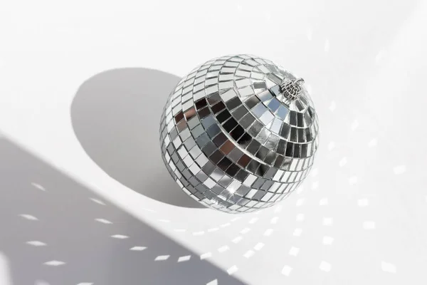 Shining disco ball on white background. Disco ball with bright rays - Image
