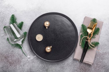 Siyah seramik tabak, cam ve köknar ağacından yapılmış ağaç dallı bir Noel sofrası. Üst Manzara. Uzayı kopyala - Resim