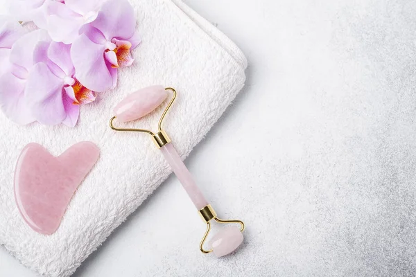 Gua Sha masaj aleti ve arka planda yüz silindiri. Yaş, kaldırma ve tonlama tedavisi. Metnin için alanı kopyala - Resim