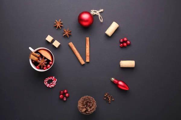 A clock in the form of spice for mulled wine. Cinnamon, anise stars, cranberries, brown sugar. Concept, creative work. Time to cook mulled wine. Top view. Black background