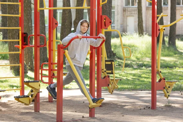 Samotny młodzieniec ćwiczący na boisku sportowym w parku, trening uliczny fitness na zewnątrz — Zdjęcie stockowe