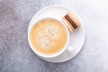 Kahveli ve beyaz tabakta çikolatalı makaronlu bir fincan. Kahve molası, üst görünüm - Görüntü