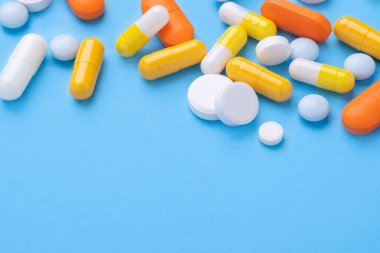 Mavi arka planda bulunan çok renkli tabletler ve haplar çeşitli ilaç tabletleri ve haplar. Sağlık hizmetleri, yakın çekim kopyalama alanı