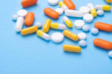 Mavi arka planda bulunan çok renkli tabletler ve haplar çeşitli ilaç tabletleri ve haplar. Sağlık hizmetleri, yakın çekim kopyalama alanı