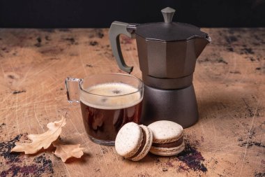 Kahve makinesi, bir fincan kahve ve ahşap arka planda çikolatalı kurabiye. Samimi sonbahar kompozisyonu - Resim