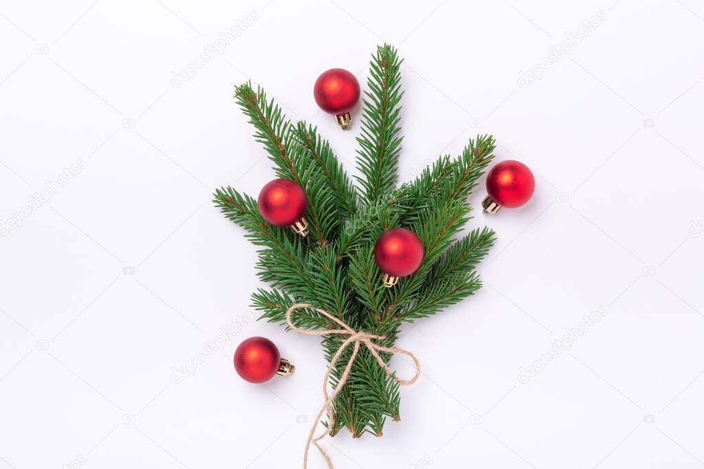 Minimal christmas composition. Bouquet of fir tree branches with red christmas balls on white background - Image