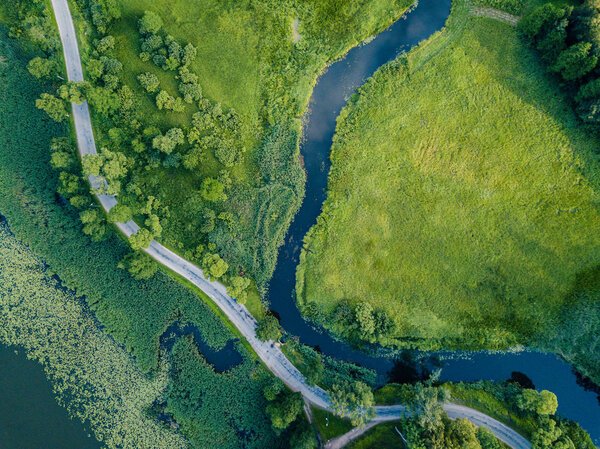 Aerial Photo of Road going by the River under the Trees, Top Down View in Early Spring on Sunny Day - Concept of Peaceful Life in Countryside in Harmony
