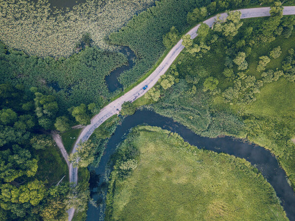 Drone Photo of Car Driving on the Road by the River under the Trees, Top Down View in Early Spring on Sunny Day - Concept of Peaceful Life in Countryside and Traveling, Freedom, Vintage Film Look