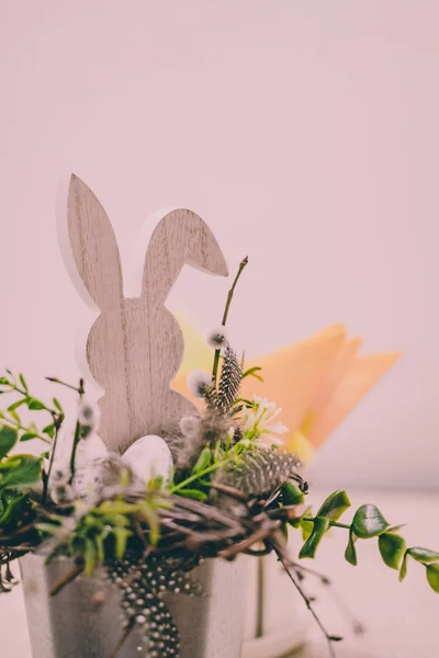 Isolated Handmade Easter Decorations (Wooden Bunny with Blossom Flowers in a Bucket on Table) - Concept of the Harmony and Peace in Family