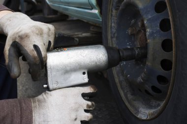 Pnömatik matkap yeşil araba lastik dan vida gevşeterek adamla | eldiven | pas