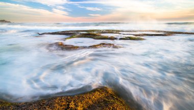 Büyük Otway Milli Park, Victoria, Avustralya Johanna plajda gün batımında üzerinde kayalık tidepools akan okyanus dalgalarının uzun pozlama.