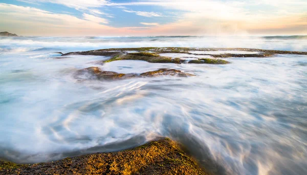 Büyük Otway Milli Park, Victoria, Avustralya Johanna plajda gün batımında üzerinde kayalık tidepools akan okyanus dalgalarının uzun pozlama.