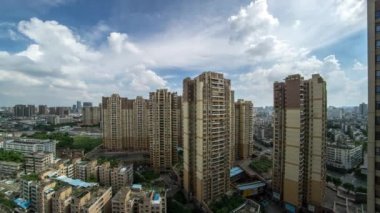 Foshan şehir, Guangdong Eyaleti, Çin görünümü. Büyük bir şehirde uzun boylu binalar ve bulutlar-Cityscape Timelapse