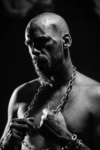 black and white portrait of a brutal man tearing the chain