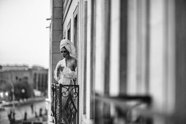 Balkonda duran beyaz cüppe seksi kız