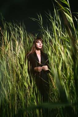 Woman in black suit in the high grass