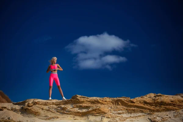 Bella ragazza sportiva in piedi sulla sabbia sulla spiaggia — Foto Stock