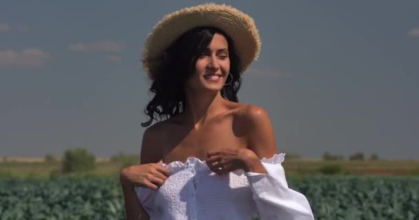 Une fille en robe blanche se tient sur un champ vert — Video