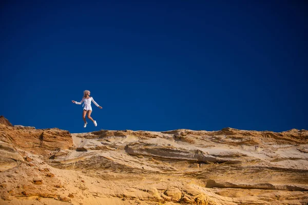 Alegre chica saltando contra el cielo azul — Foto de Stock