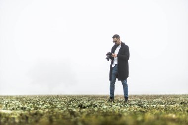 Bir doğa fotoğrafçısı kameraya bakar.
