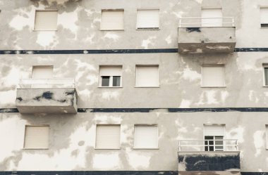 Boyanmayı bekleyen yamalar ile gri bina cephesi