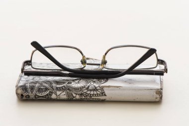 Eski bardaklar cep telefonunda duruyor beyaz arka planda eski ve pejmürde bir çanta, nesneleri izole ediyor.